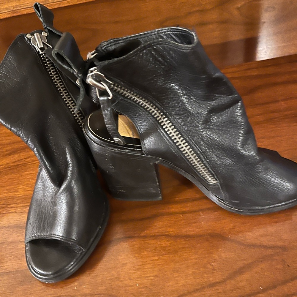 Black leather open toe and heel shoes with size zippers.